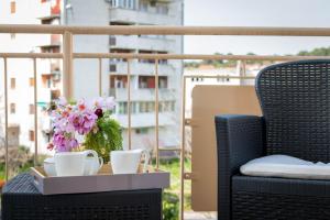 普拉MIRSOL Sunny Apartment的阳台上装有两杯和鲜花的托盘