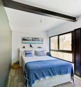 阿利坎特Precioso loft en el corazón de Alicante的一间卧室配有一张带蓝色毯子的大床