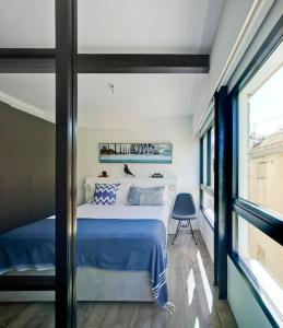 阿利坎特Precioso loft en el corazón de Alicante的一间卧室配有一张带蓝色床单的床和一扇窗户。