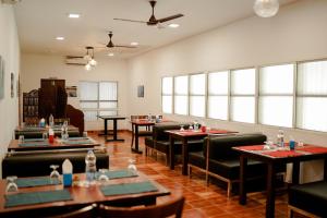马拉利库兰Marari Beach Palace的用餐室设有桌椅和窗户。