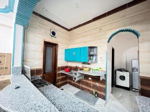 Jazīrat al ‘AwwāmīyahRiver view的厨房配有蓝色橱柜、水槽和微波炉