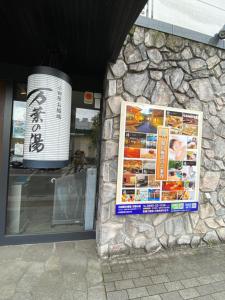 小田原市花沢民宿的石头建筑的一侧的标志