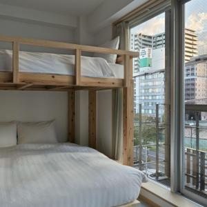 福冈DD HOTEL 中洲的一间卧室设有一张双层床和大窗户。