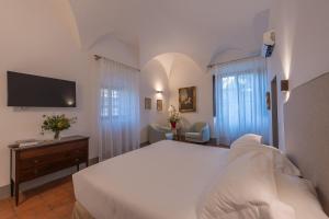 基安蒂格雷夫Corte Di Valle的卧室配有一张白色大床和电视。