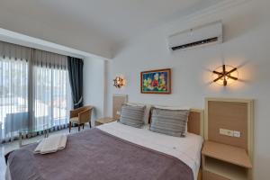 居姆贝特Sami Beach Hotel- All Inclusive的一间卧室配有一张大床和一张书桌