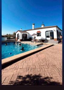 塞维利亚Casa con piscina privada的一座房子前面设有游泳池
