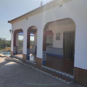 塞维利亚Casa con piscina privada的一座白色的建筑,里面设有游泳池