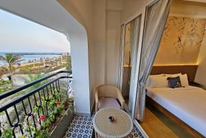 蓬蒂切里Sea Gadabout - Seaside Stays的一间卧室设有一张床和一个海景阳台。