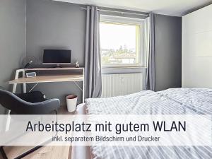 巴特萨克萨HaFe Ferienwohnung Bad Sachsa - waldnah, hundefreundlich, Smart Home Ausstattung的一间卧室配有一张床和一张带电脑的书桌