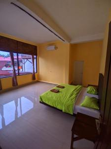 索龙Mooipark Hotel Sorong的一间卧室配有一张带绿床单的床。