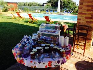 洛雷托Casale Papa Country Village的一张桌子,上面有食物,放在游泳池边