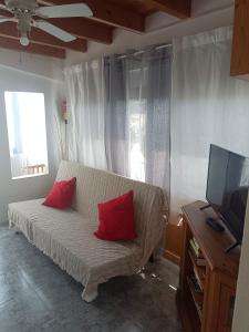 奥尔索拉Tranquilo y Acogedor Apartamento的客厅配有带2个红色枕头的沙发