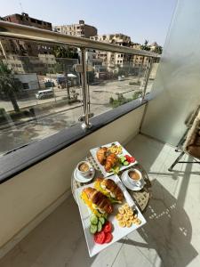 开罗Khattab Pyramids View Hotel的阳台上的一张桌子上放着两盘食物