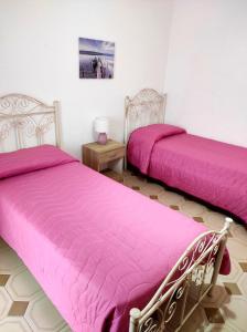 萨尔维Casa Pali-Comi的客房内的两张床和粉红色的被褥