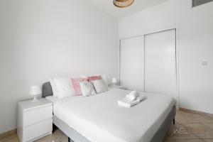 迪拜WelHome - Stylish Studio with Park Views in Regent House 2的白色的卧室配有一张白色的大床和镜子