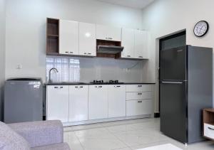 金边LSP Hotel & Apartment的厨房配有白色橱柜和黑色冰箱。
