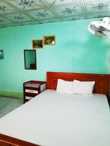 Rạch TàuHomestay Nguyễn Hùng的卧室配有白色的床和电视。