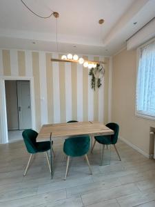 雷诺河畔卡萨莱基奥EDC home con parcheggio e self check in的一间带木桌和绿色椅子的用餐室