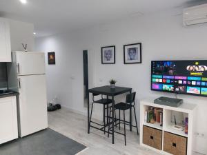 贝纳阿维斯Los Pinos 8的客厅配有桌子、电视和冰箱。
