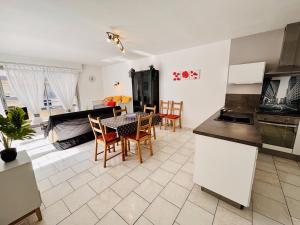 鲁西隆地区卡内Superbe Appartement Vue mer的厨房以及带桌椅的起居室。