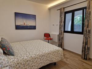 圣布里希达Casa con piscina, High-speed Wi-Fi y vistas的一间卧室配有一张床和一张红色椅子