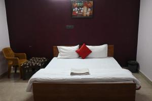 博帕尔Hotel The New Lake Palace的一间卧室配有一张带两个红色枕头的床
