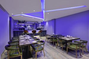 乌代浦Hotel The Rising的一间设有桌椅和紫色墙壁的用餐室