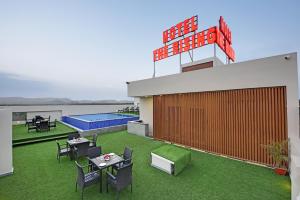 乌代浦Hotel The Rising的一个带桌椅的屋顶露台和游泳池