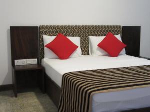YatiyantotaMiridiya Resort的一间卧室配有一张带两个红色枕头的床