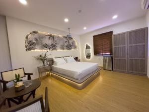胡志明市AIRIE LIVING的一间卧室配有一张床铺和一张桌子,还有一间用餐室