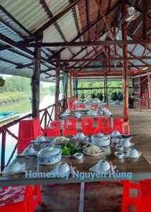 Rạch TàuHomestay Nguyễn Hùng的桌上放着碗和盘子的食物