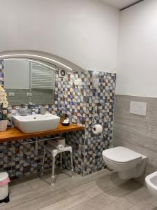 斯培西亚Vita lenta - rooms的一间带水槽、卫生间和镜子的浴室