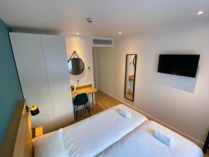 安纳马斯Oskar Hotel的卧室配有白色的床和书桌