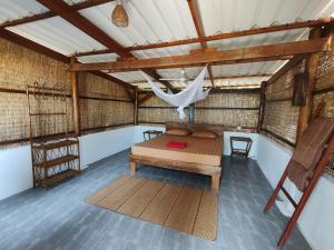 高龙撒冷岛KAMAKU Bungalows的一间设有床铺和吊床的客房