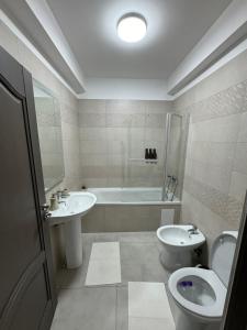 苏恰瓦Sunrise paradise的浴室配有盥洗盆、卫生间和浴缸。