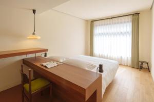 德清莫干山·木可合作社的一间卧室配有一张床、一张书桌和一个窗户。