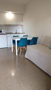 罗列特海岸马利波萨公寓式酒店的厨房配有白色的桌子和蓝色的椅子