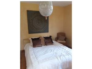 Savignac-de-DurasMaison Les Bardots的卧室配有白色的床和吊灯。