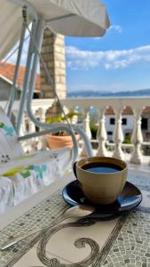比耶拉Family House with pool & sea view的坐在阳台上的桌子上喝杯咖啡
