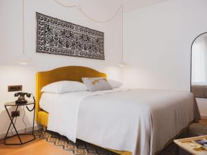 奥尔比亚Tramas Hotel & Spa的卧室配有白色的床,墙上挂着一幅画