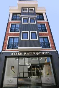 恰纳卡莱Aybek Ratio Hotel的一座高大的建筑,上面标有读阿尔法比的酒店