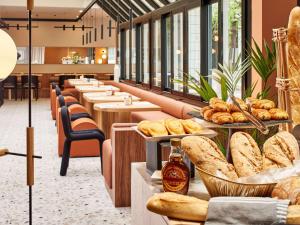 巴黎巴黎凡尔赛15号美居酒店的一排餐桌,上面放着面包和糕点