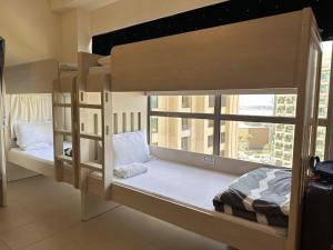 迪拜Bollywood Beach Hostel的带窗户的客房内的两张双层床