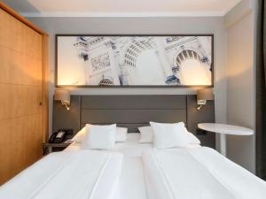慕尼黑慕尼黑斯彻瓦宾美居酒店的一张大白色的床,上面有一张大照片