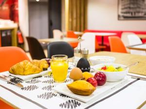 波尔多波尔多市中心圣让车站欧洲大西洋宜必思酒店的一张桌子,早餐包括鸡蛋、水果和果汁