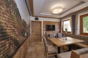 萨尔巴赫加比膳食公寓酒店的一间带桌子和大电视的用餐室