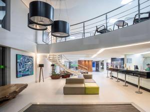 贝伦Ibis Styles Belém Hangar的一个带楼梯和沙发的办公大厅