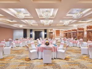 焦特布尔Novotel Jodhpur ITI Circle的宴会厅配有桌椅和吊灯