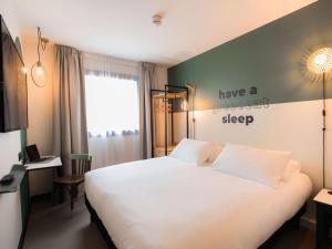 GuipavasGreet Hotel Brest Aéroport的卧室配有白色的床,墙上挂着甜美的睡眠标志