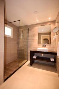纳布勒CALIMERA Delfino Beach Resort & Spa的一间带玻璃淋浴和水槽的浴室